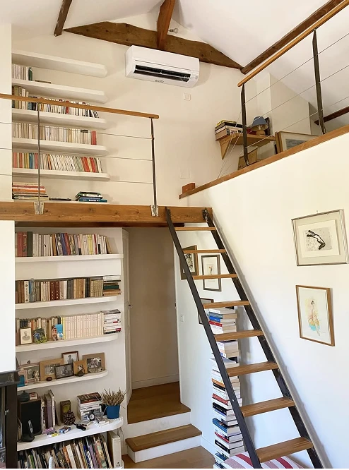 Climatiseur mural blanc dans une bibliothèque avec mezzanine