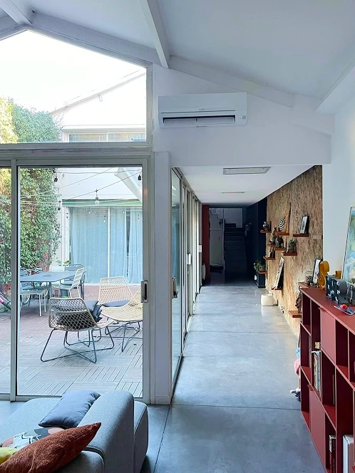 Climatiseur mural blanc dans un couloir lumineux ouvert sur une terrasse