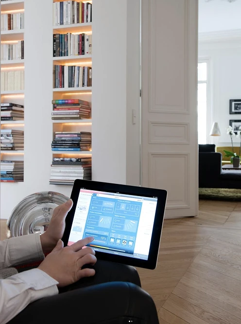 Personne utilisant une tablette de contrôle pour piloter la climatisation