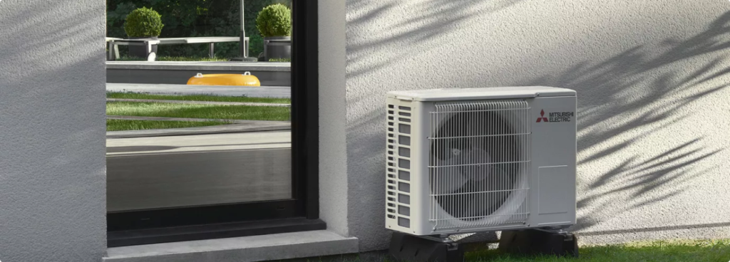 Unité extérieure de climatisation installée sur un mur en crépi