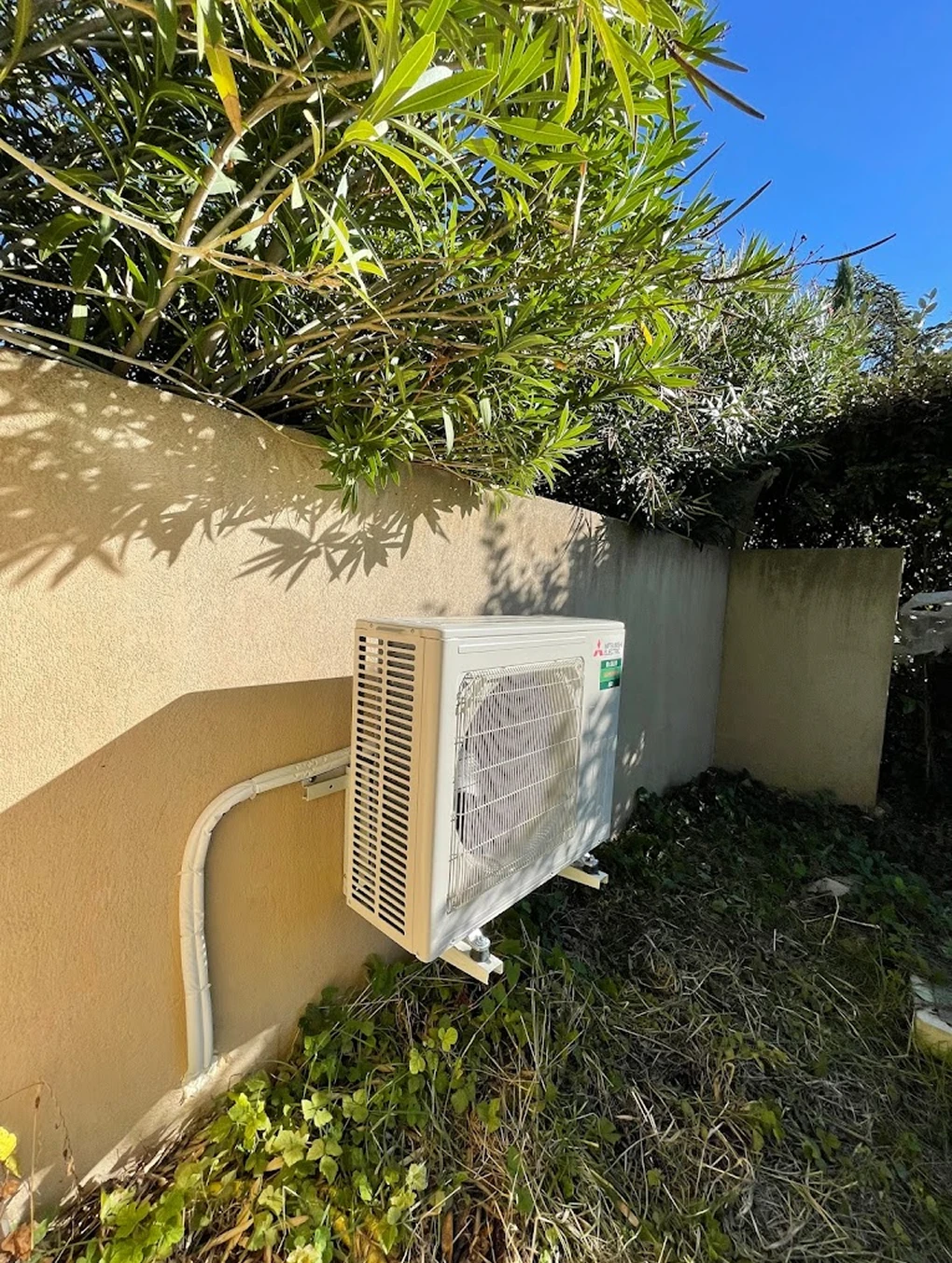 Unité extérieure de climatisation installée dans un jardin